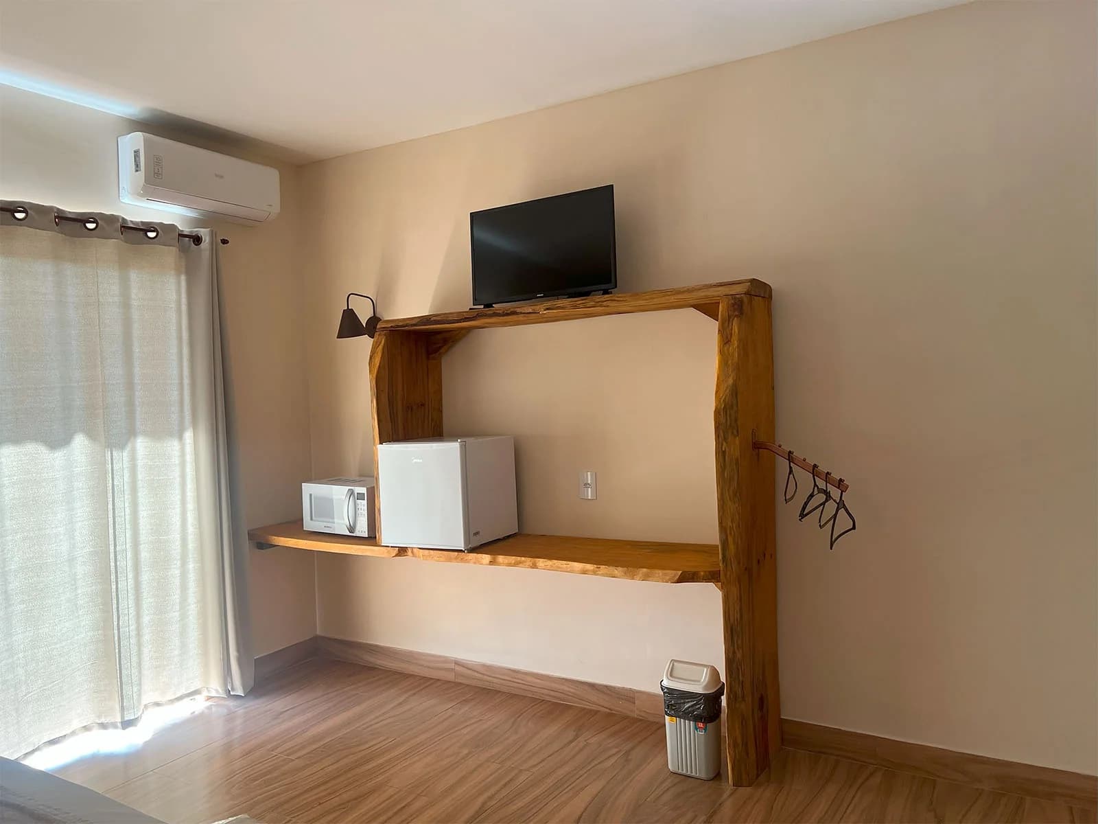 Apartamento · Sala com estante de madeira e TV